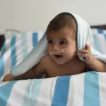 A Heartwarming Moment: The Little Child Radiantly Smiles with Innocent Joy