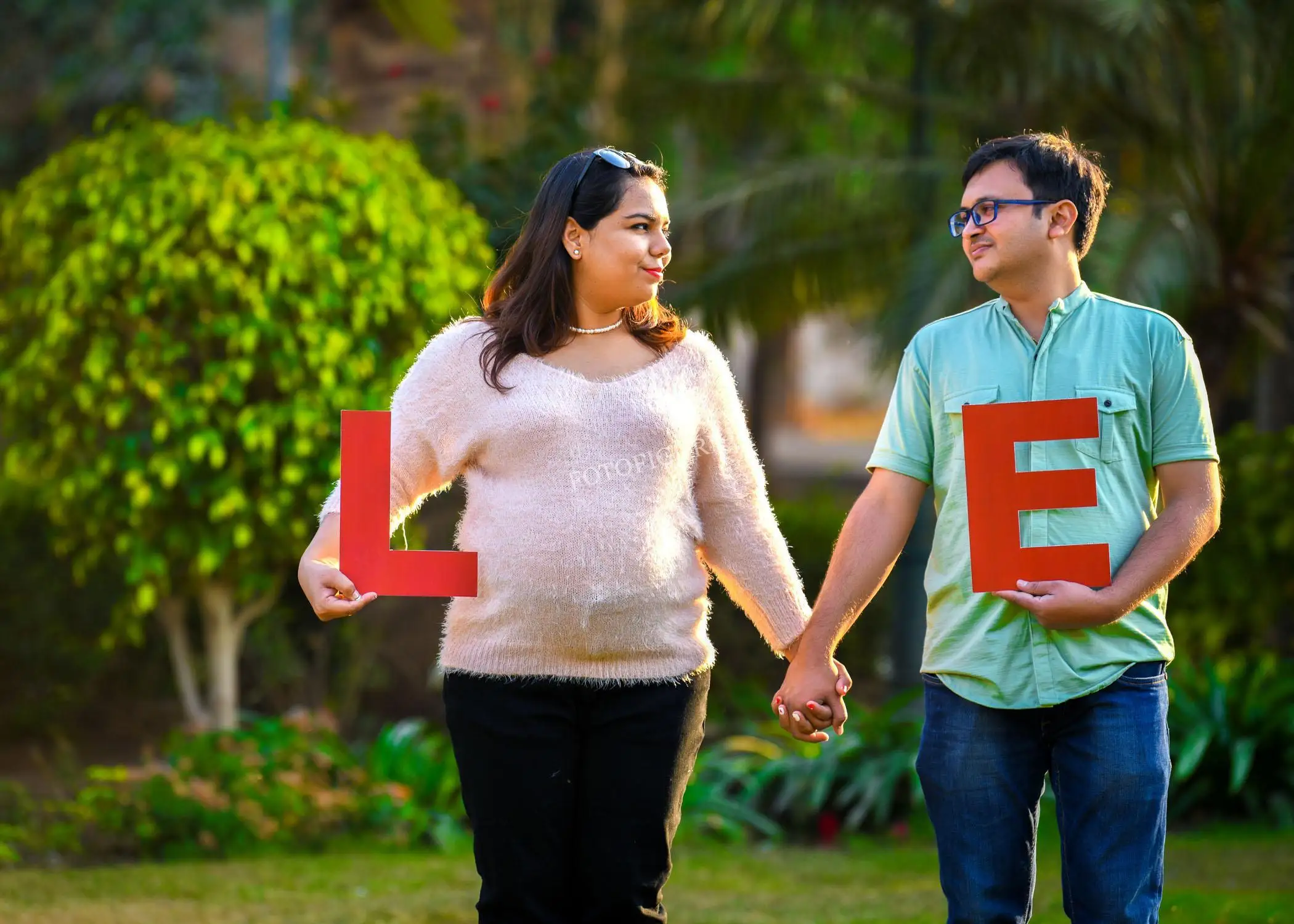 Expectant husband and wife embracing their growing family